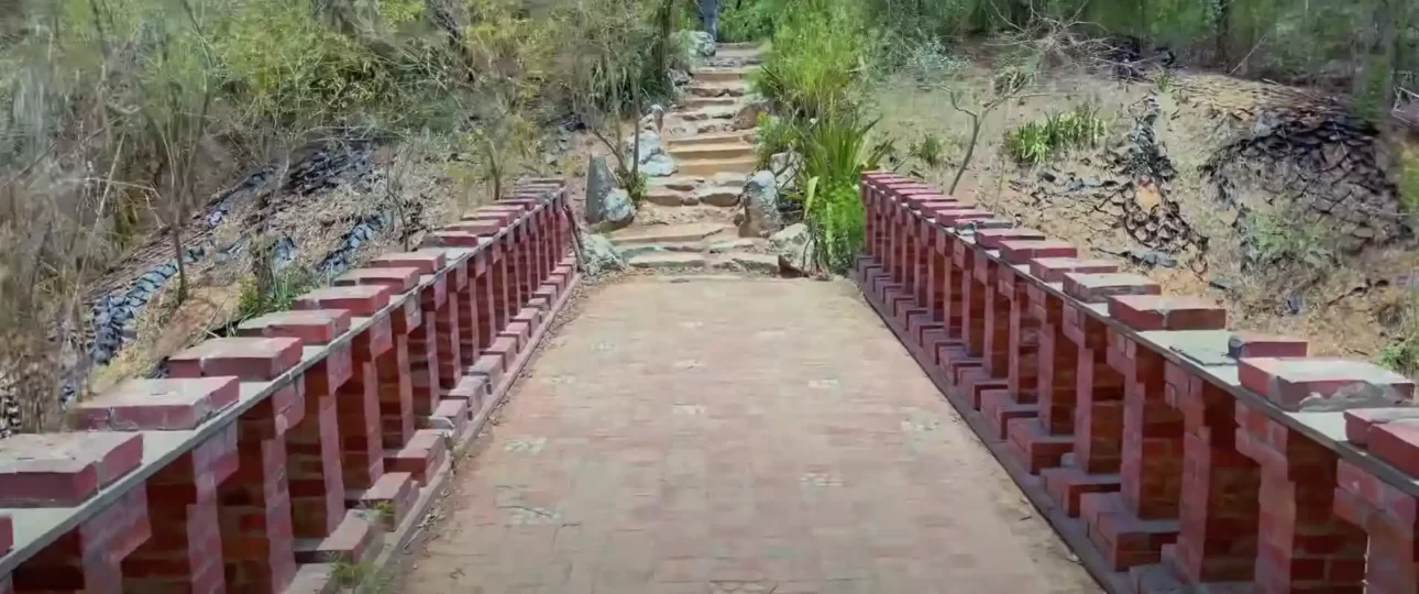 a brick path with a railing and rocks of Smriti Van, Jaipur